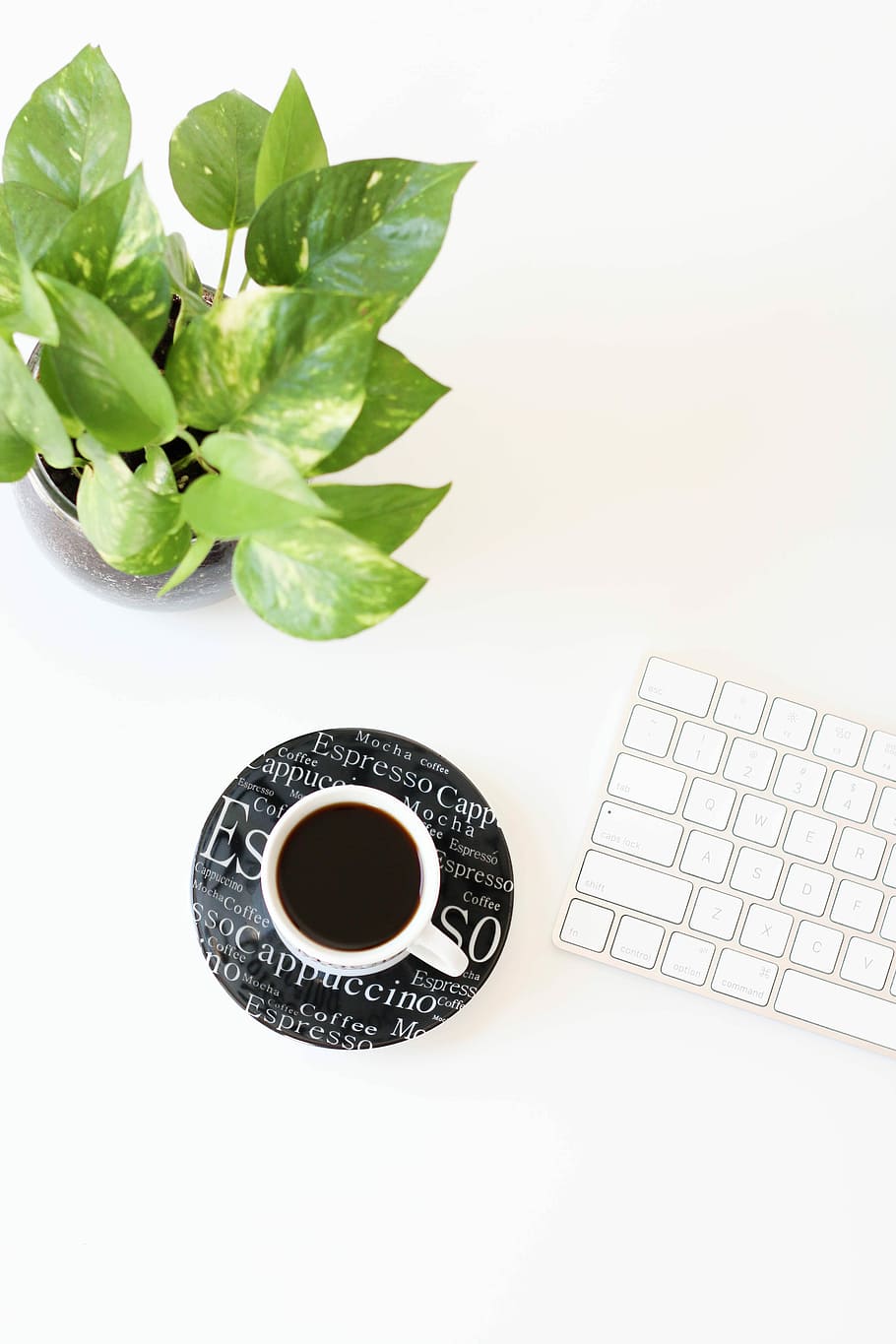 black liquid in white ceramic cup beside keyboard, white ceramic mug on black coaster beside Apple magic keyboard HD wallpaper