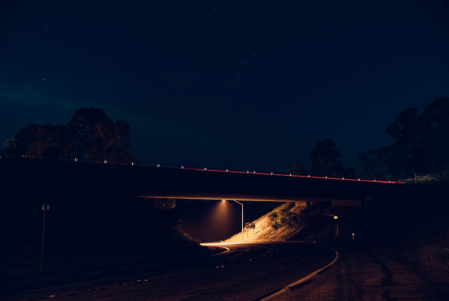 highway during daytime, silhouette photography of lighted bridge over empty road HD wallpaper