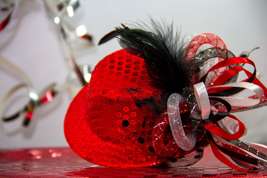 closeup photography of red sequined fascinator hat, carnival