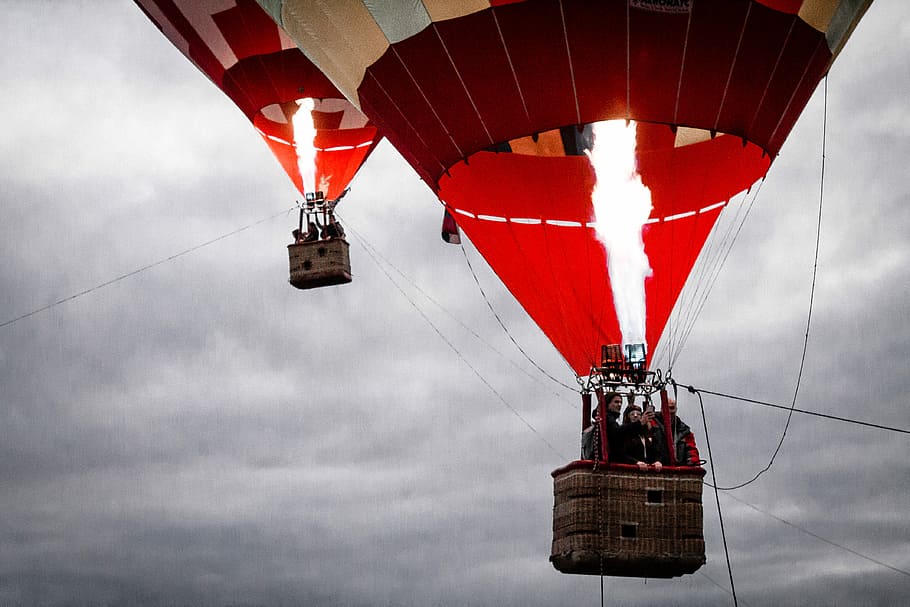 people on red and beige air balloons, photo of two a red lighted hot air balloons at the sky, HD wallpaper