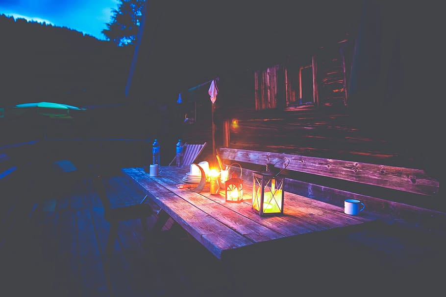 lightened candle inside candle holder on brown wooden table HD wallpaper