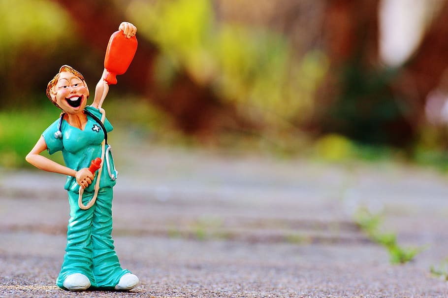 macro photography of doctor holding stethoscope and water bag toy HD wallpaper