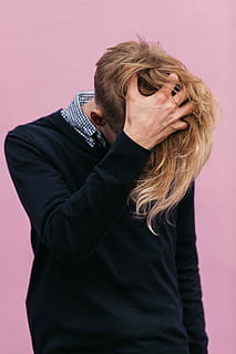 blonde hair man wearing black sweater scratching he's head during daytime HD wallpaper