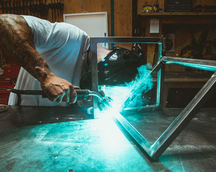man welding two rectangular gray metal frames, man wearing welding helmet molding frame HD wallpaper