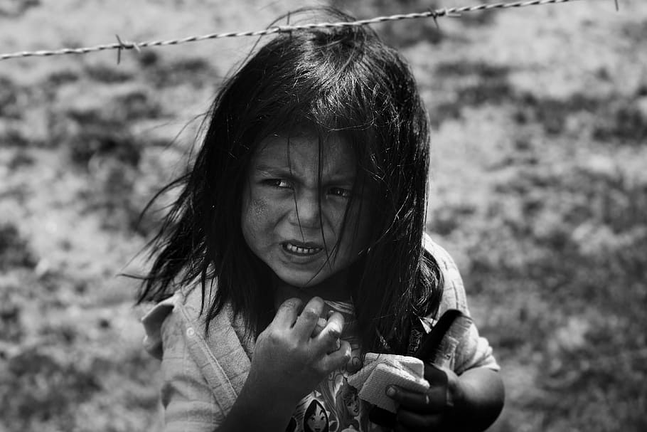 girl holding hair comb behind barbed wire, grayscale photography of girl standing under steel barbed wire