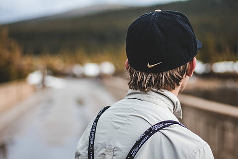 selective focus photograph of person in gray collared shirt and black Nike curve-brimmed cap, person looking at far HD wallpaper