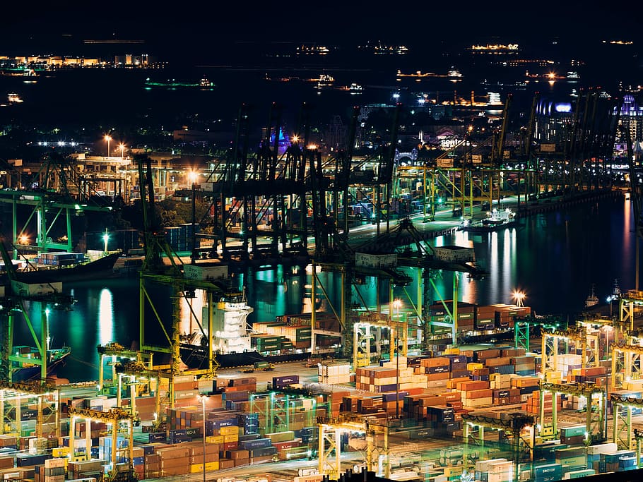 scaffoldings and metal racks near body of water and lighted building during nighttime, aerial view of cargo ship on dock HD wallpaper