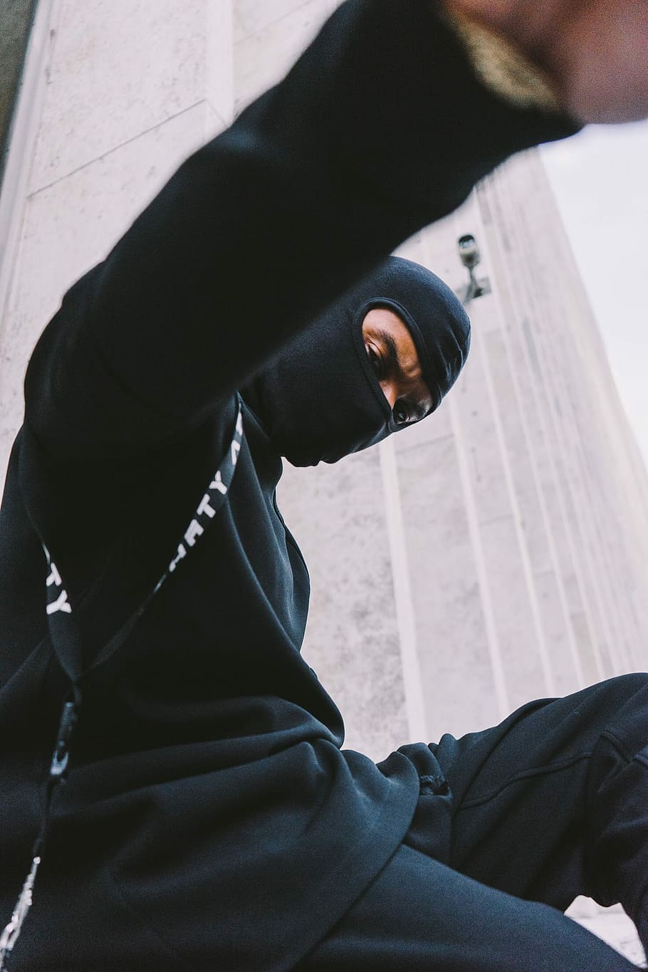 man wearing black balaclava, portrait, ninja, building, one person
