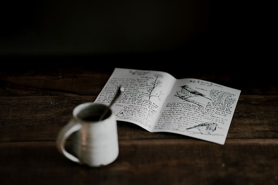 mug near book on wooden surface, mug beside white printer paper HD wallpaper