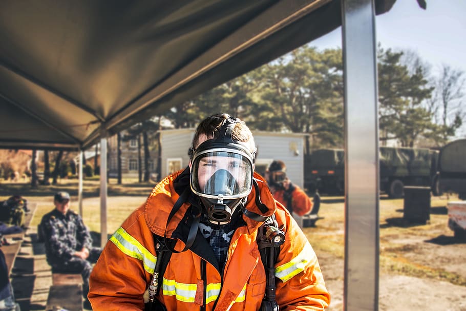 shallow focus photography of firefighter in full suit, firefighter taking picture during daytime