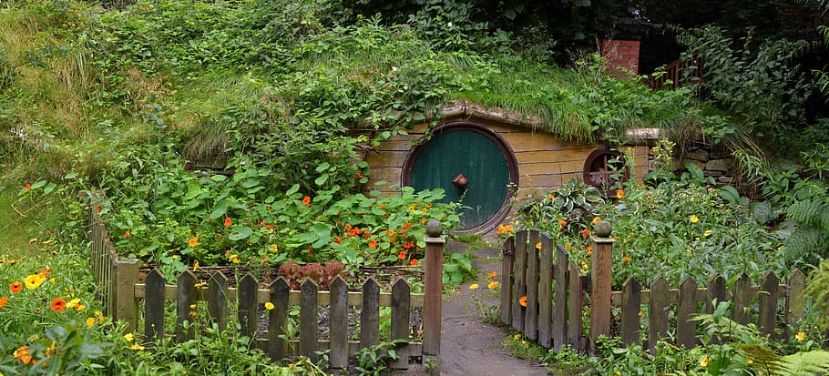 photo of shire with green plants and brown wooden fence, hobbit