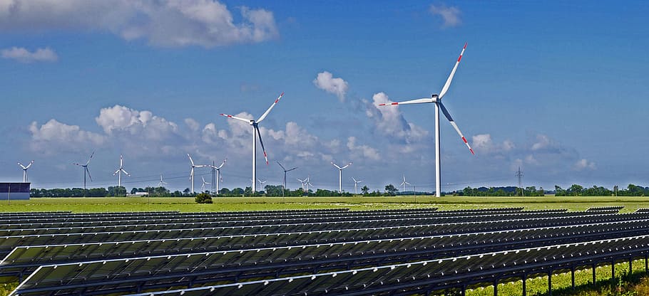 photo of wind turbine on field near solar panel, solarpark, wind park