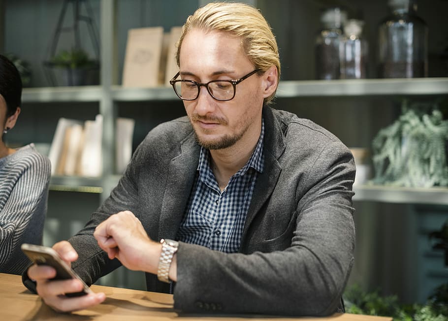 man sitting on chair while leaning on table, phone, watch, time HD wallpaper