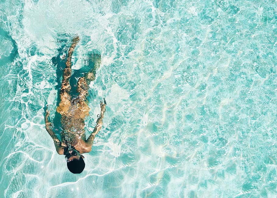 man snorkeling under water, high angle photo of person swimming under body of water