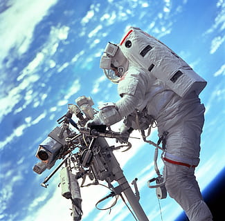 astronaut holding machine with planet Earth background, spacewalk HD wallpaper