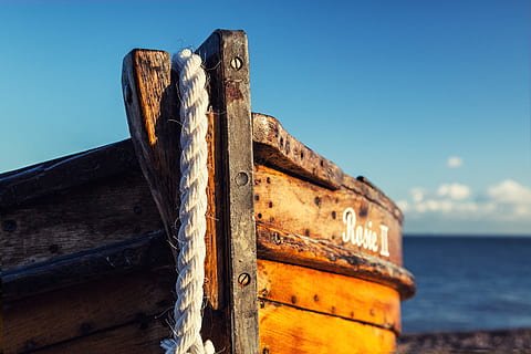 A wooden fishing boat rests on the beach on a sunny day in Deal in Kent, England HD wallpaper
