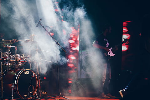 musical band playing on stage, photo of man holding electric guitar near drum set HD wallpaper
