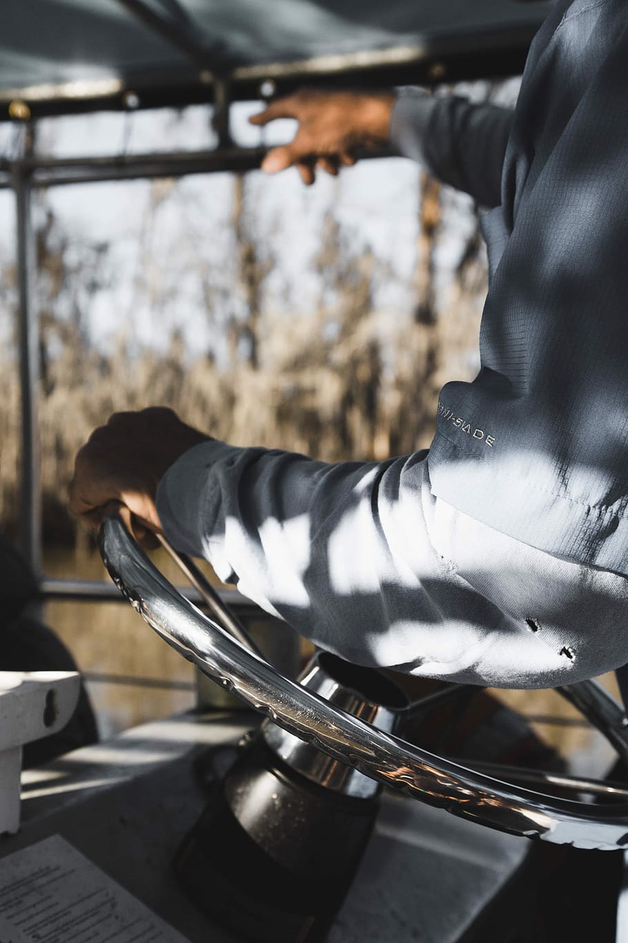 person holding boat steering wheel, person riding vehicle while pointing on glass window during daytime HD wallpaper