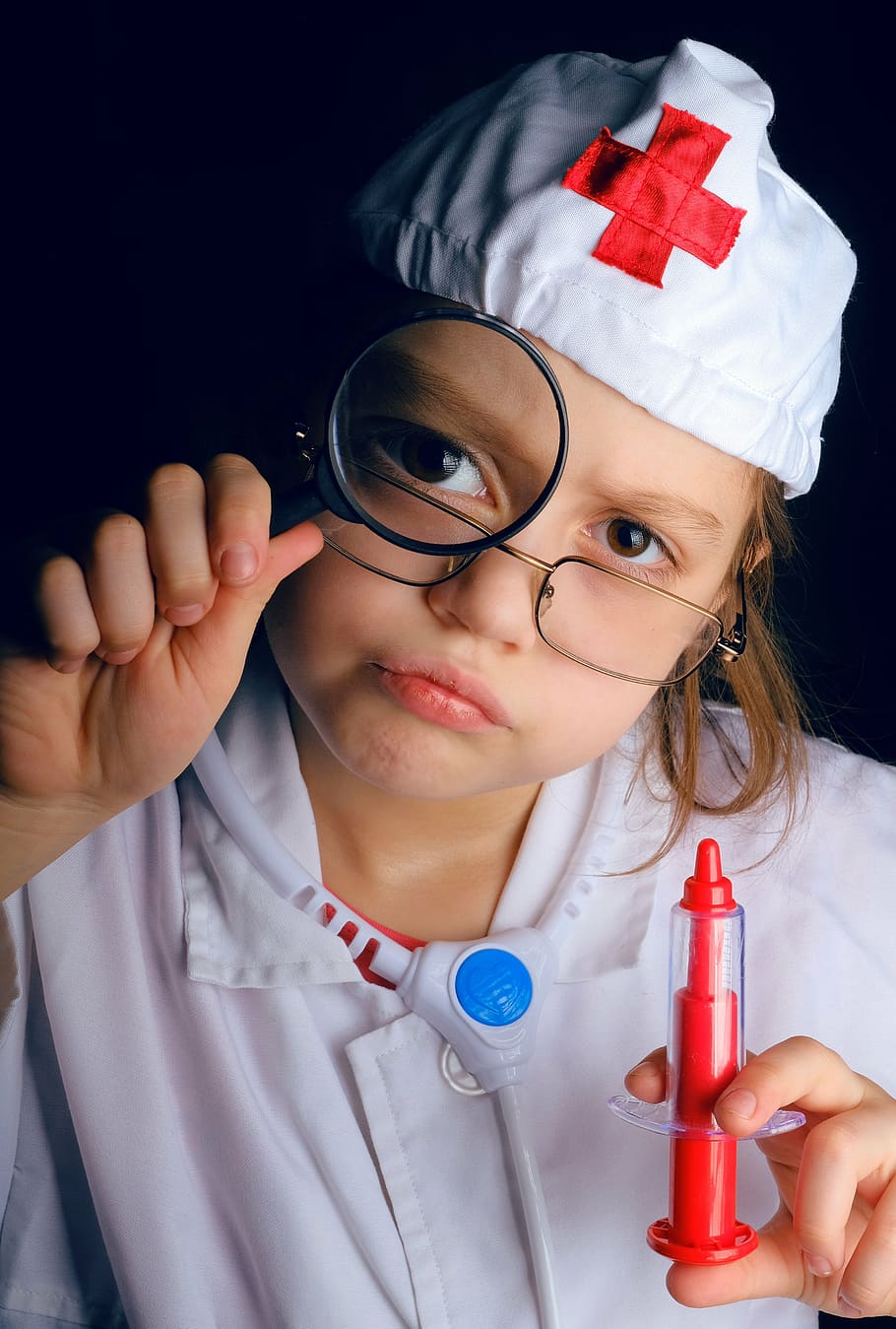 child wearing doctor costume holding syringe toy, ambulance, students