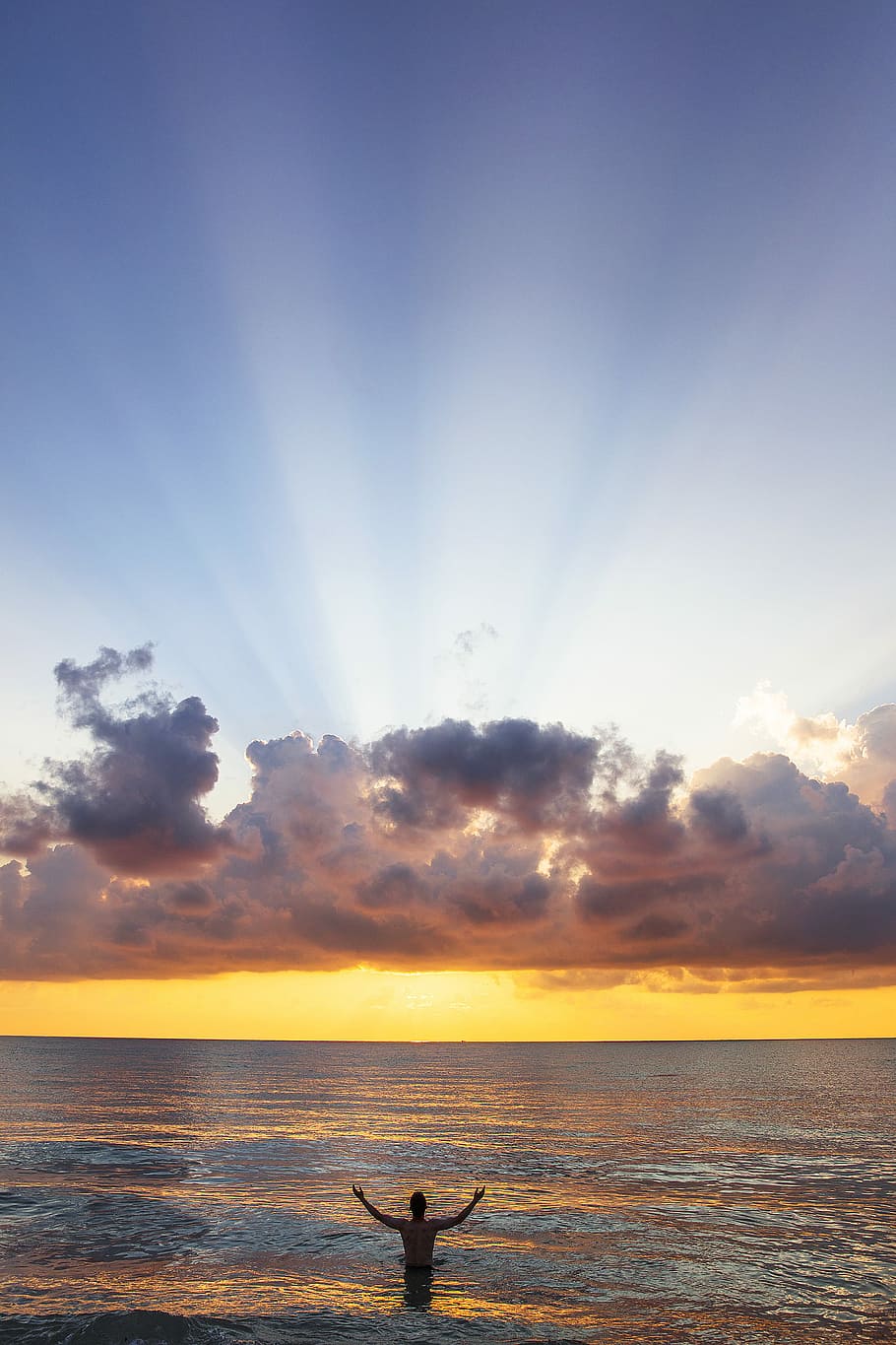 man raising his arms on sea under black clouds, person standing on body of water HD wallpaper