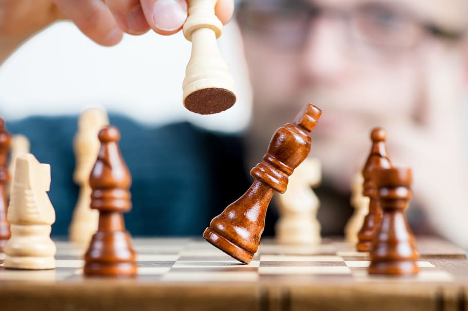 Download A Person Is Playing Chess On A Board Wallpaper