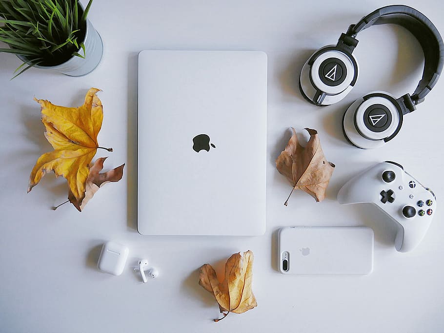 MacBook beside headphones, MacBook Pro near white and black wireless headphones HD wallpaper