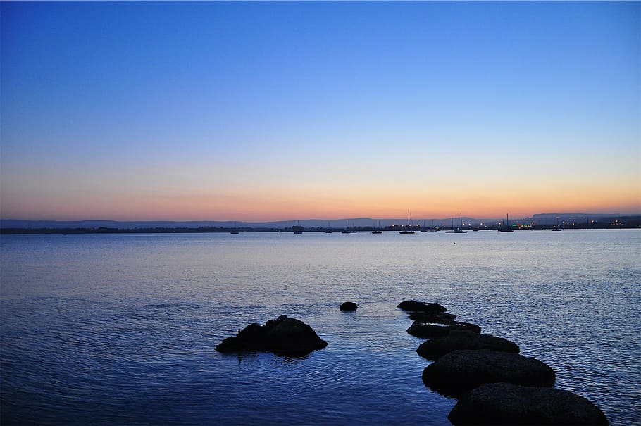 seascape photography of city skyline, sunset, dusk, dark, lake HD wallpaper