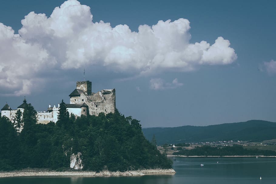 castle on cliff under white clouds and blue sky, gray building on mountain top near sea HD wallpaper