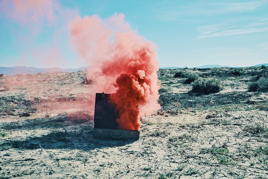 gray case with pink smoke, briefcase with red smoke during day time HD wallpaper