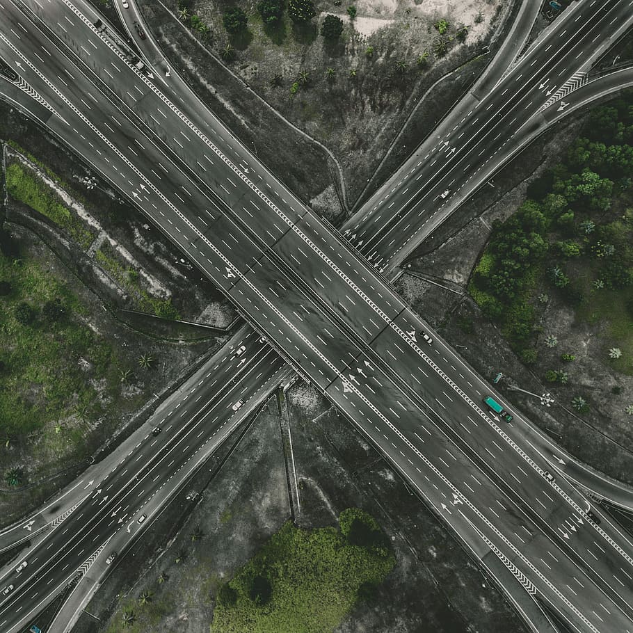aerial photography of road, gray road structure between trees HD wallpaper