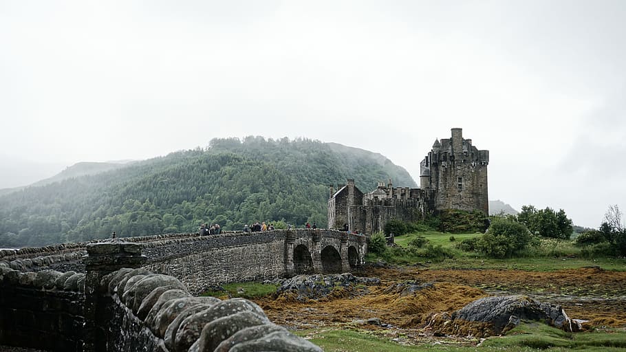 stone wall with tower beside mountain, gray concrete castle under cloudy sky at daytime HD wallpaper