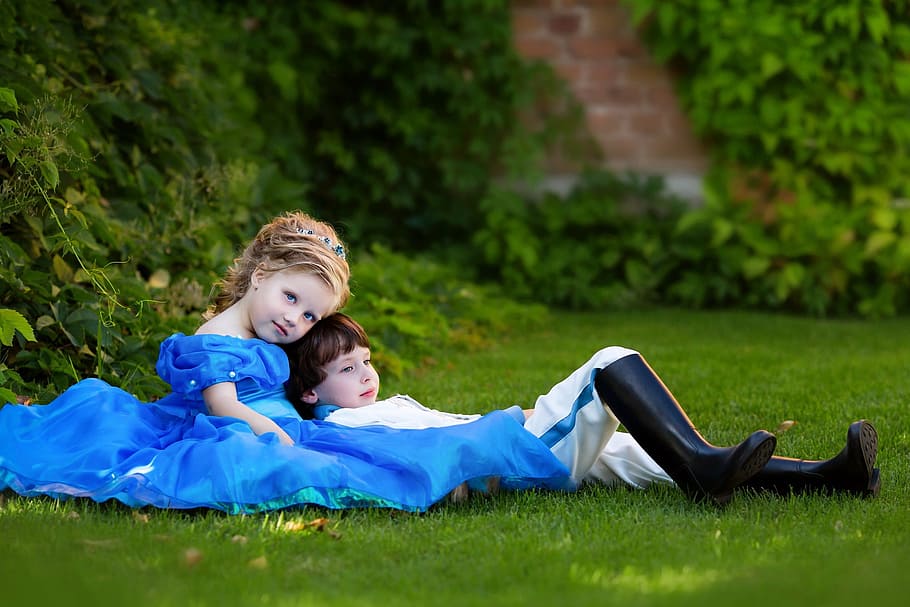 two girl and boy wearing dresses lying down on green grass field, HD wallpaper