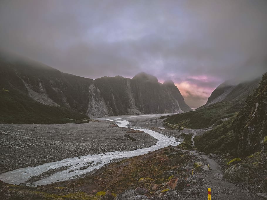 river in between brown hill, river and mountains in landscape photography HD wallpaper