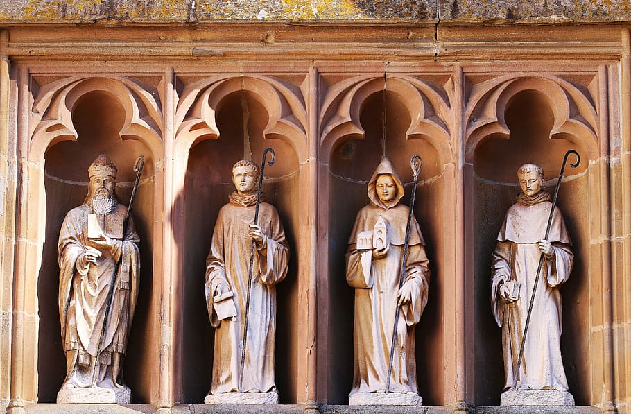 photo of four concrete statues, figurengruppe, stone figures