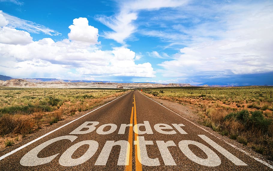 Border Control text on road, Stop, field, sky, clouds, country border