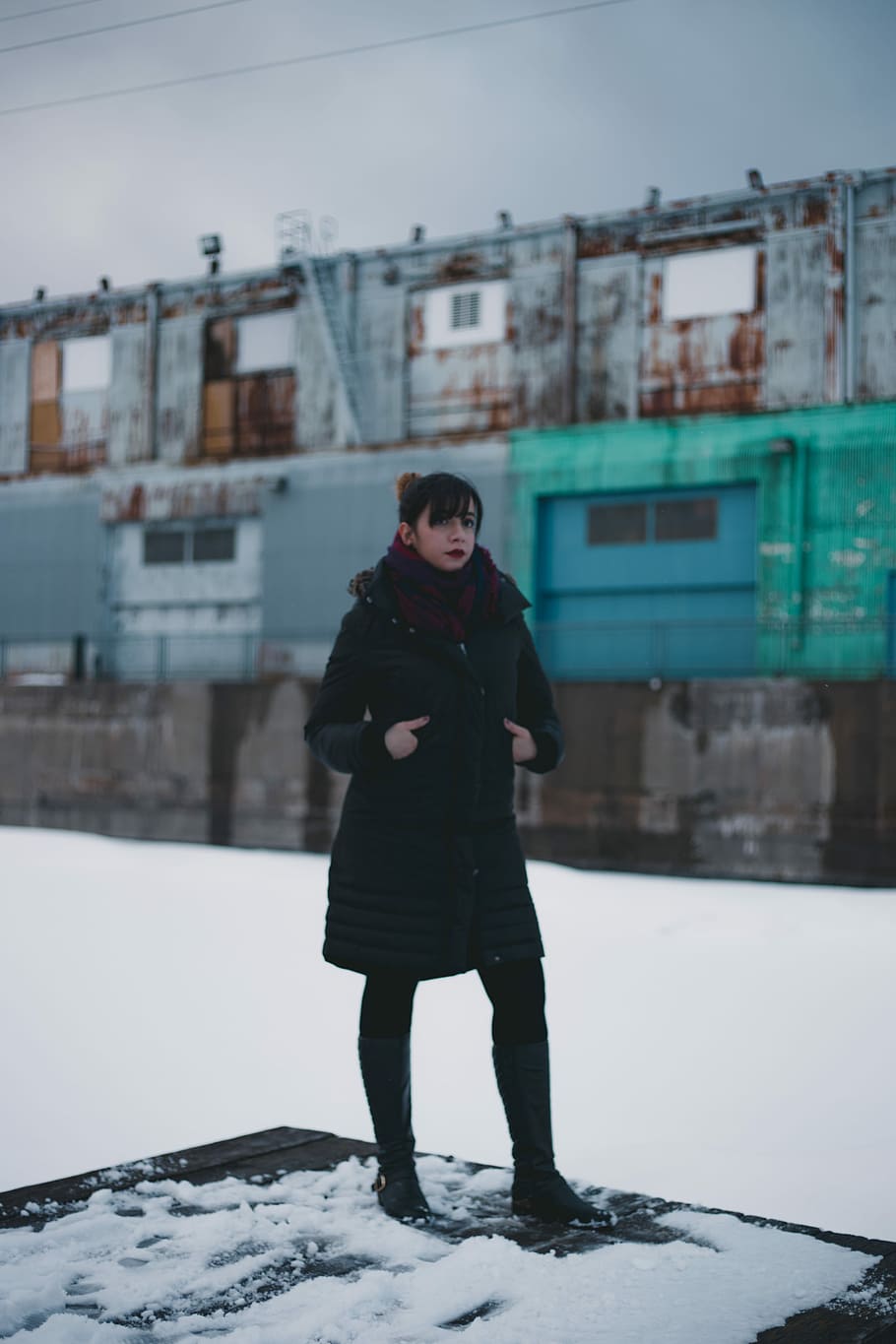 selective focus photography of woman wearing overcoat standing on intermodal container, women's black and red coat on snow HD wallpaper