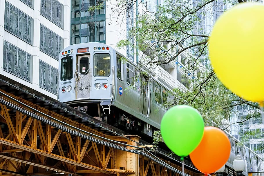white train beside building, gray train near white buildings during daytime HD wallpaper