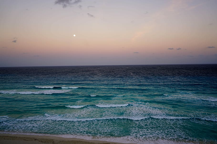 photo of green ocean during night time, cancun, mexico, beach