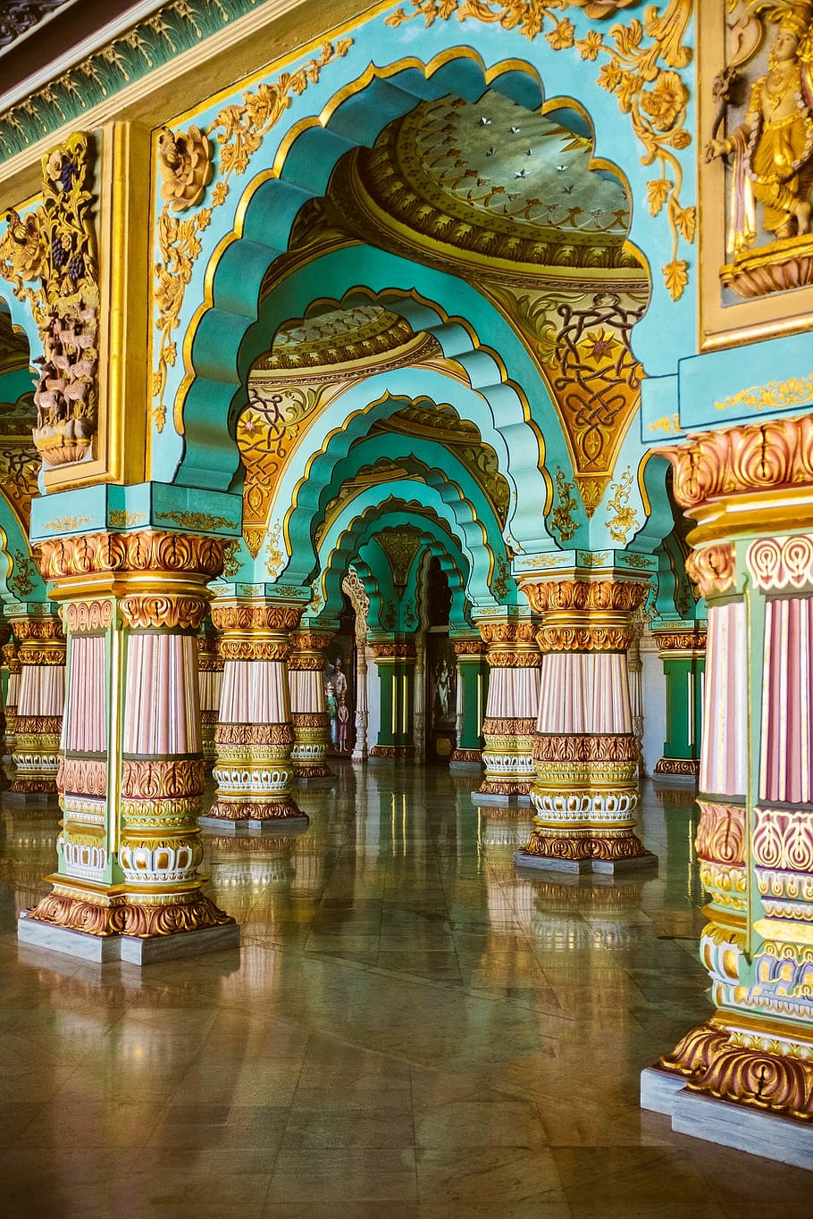 blue, yellow, and brown concrete structure, teal, gold-colored and red temple interior