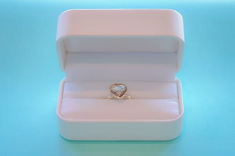 silver ring with heart stone inside case on teal surface top HD wallpaper