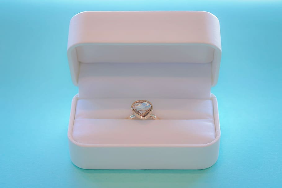 silver ring with heart stone inside case on teal surface top HD wallpaper