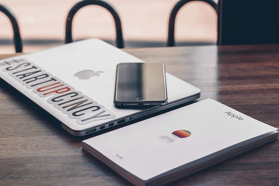 post-2016 iPhone on silver MacBook, space gray iPhone 6 on MacBook Pro on brown wooden table HD wallpaper