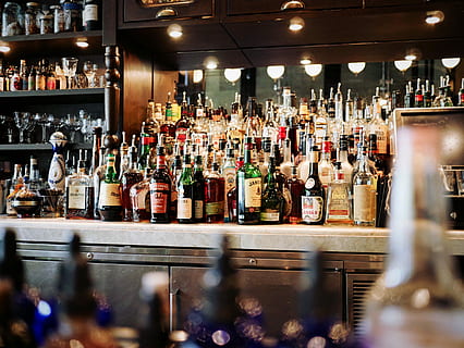 liquor bottles on white and brown wooden cabinet, piled labeled bottle on table HD wallpaper