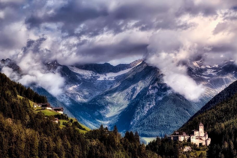 snow mountain covered with white clouds and forest below it HD wallpaper