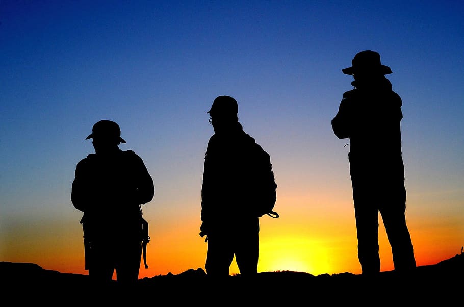 silhouette of three men during golden hour, hikers, silhouettes