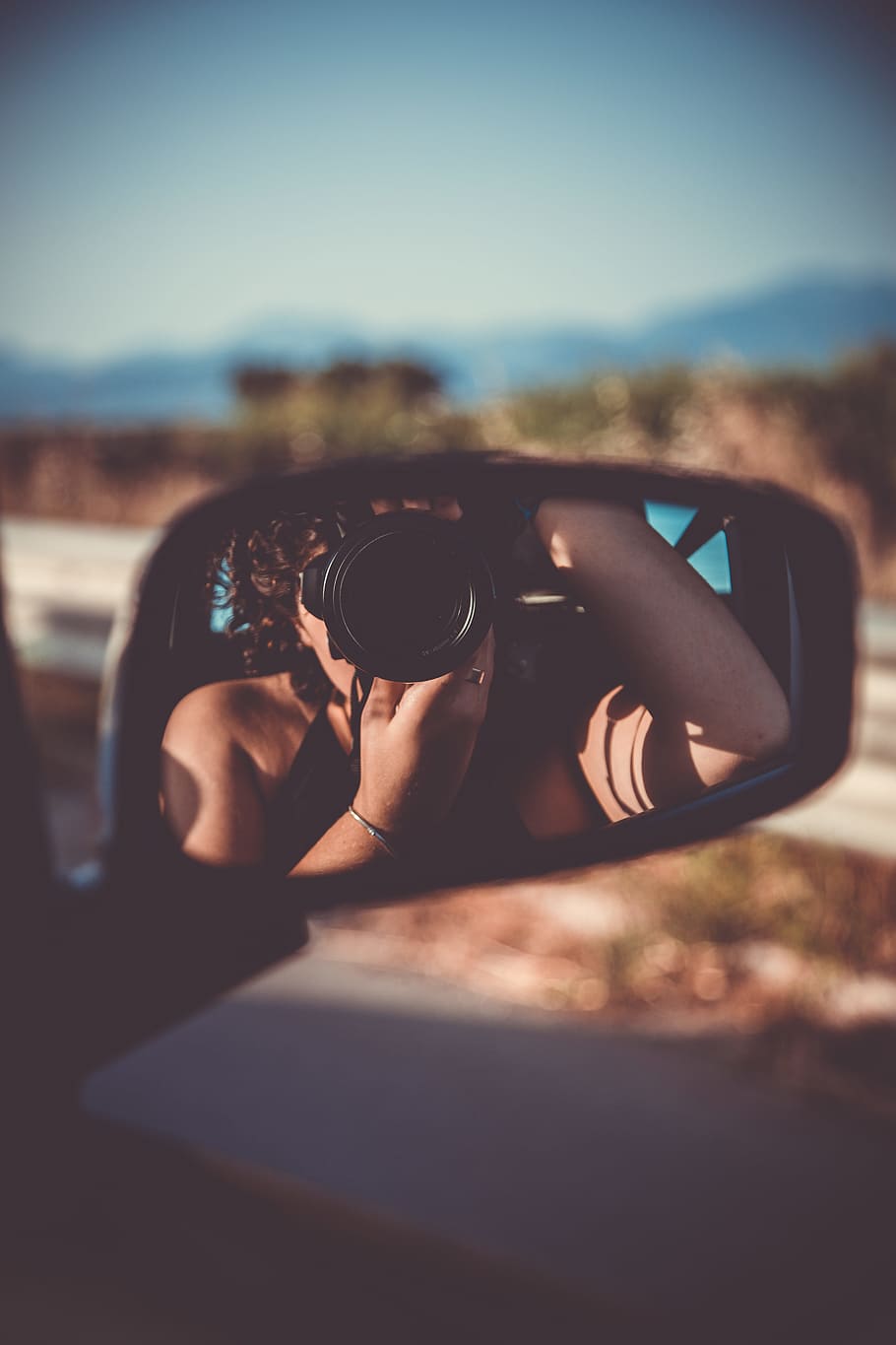person taking selfie through vehicle wing mirror, selective focus photography of car side mirror reflected the woman taking the picture using DSLR camera while inside the car HD wallpaper