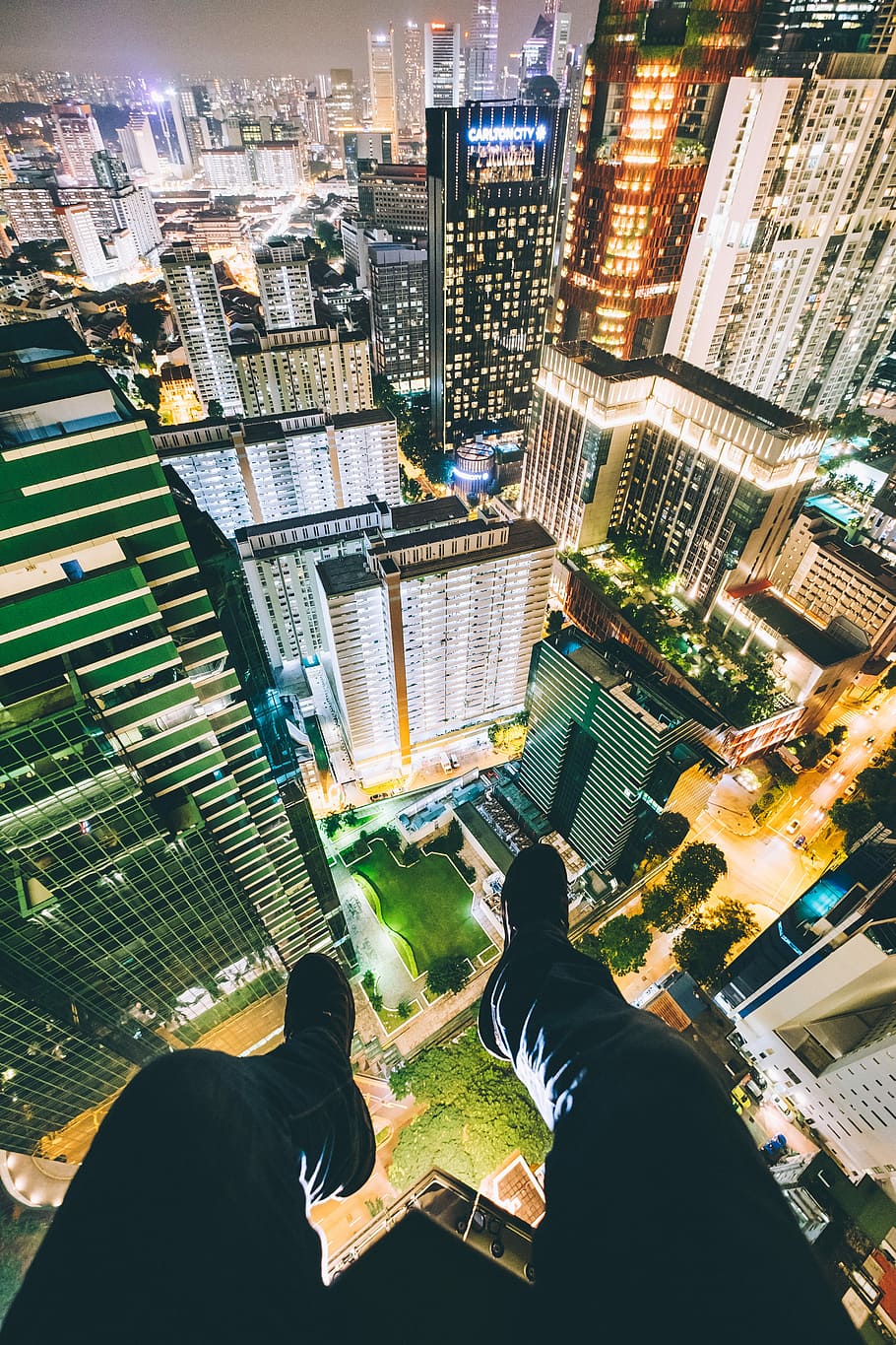 man sitting on top of high-rise buildings, aerial photograph of cityscape