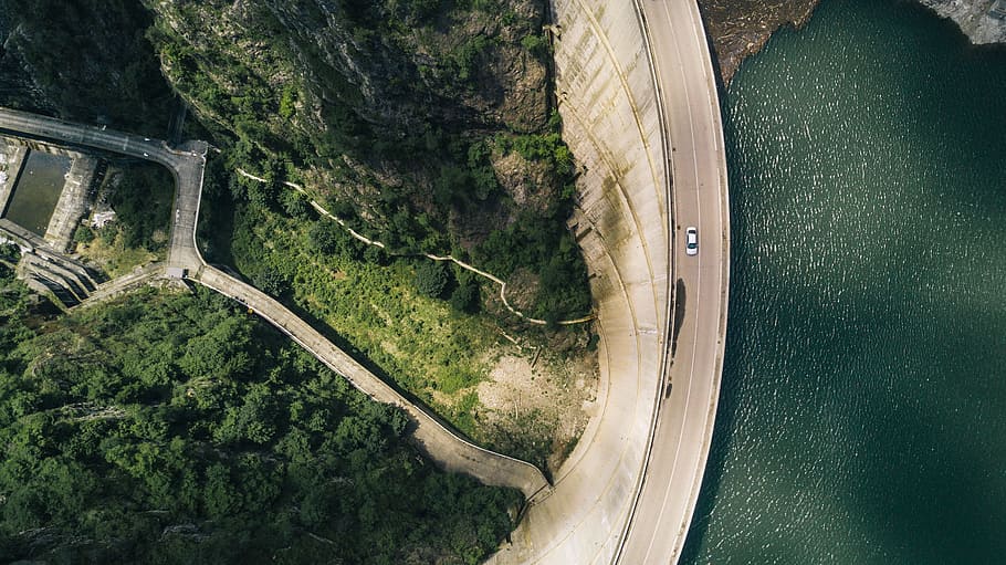 aerial photography of white vehicle on concrete road at daytime, Water dam in Romania - Drone