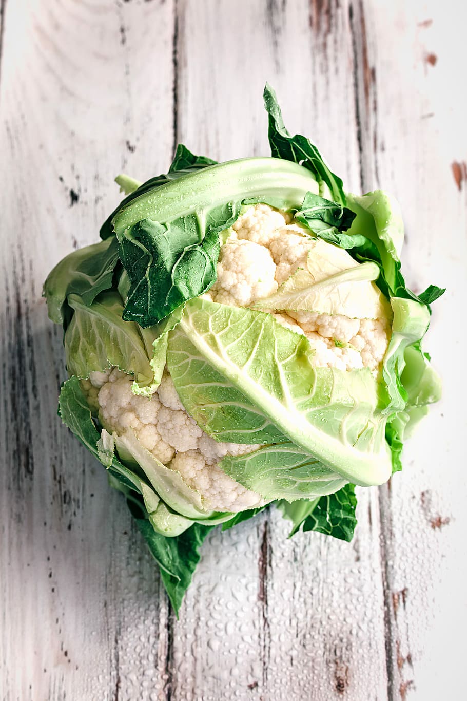 cauliflower on white wooden surface, white cauliflower, leaves HD wallpaper