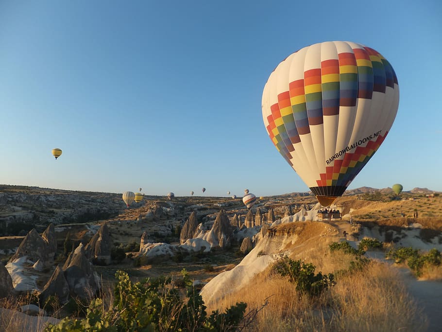 hot air balloons in flight above mountains, multicolored hot air balloons on air